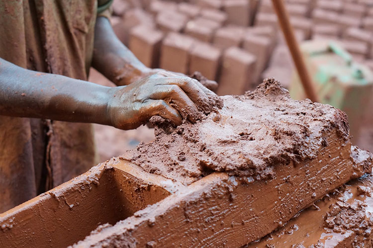 brick maker, making clay bricks by hand