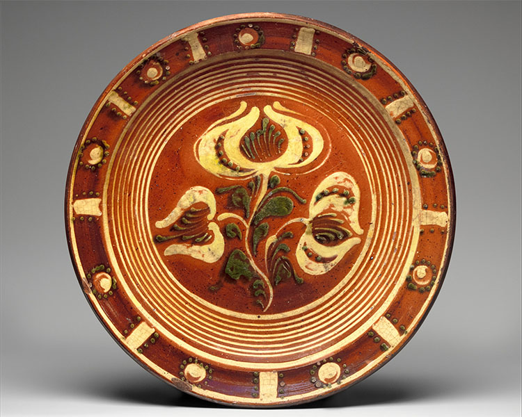 "File:Redware Slip-decorated dish MET DP335286.jpg" by Creator:Dennis Family Potters is marked with CC0 1.0.